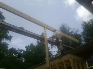 Carpenter setting a ridge beam over a new addition frame — Ice Dam Removal by Roofing Brothers in West Chazy