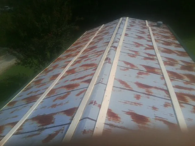 Rusted metal roof panels with new wood purlins before replacement — Storm Damage Roof Repair in West Chazy by Roofing Brothers