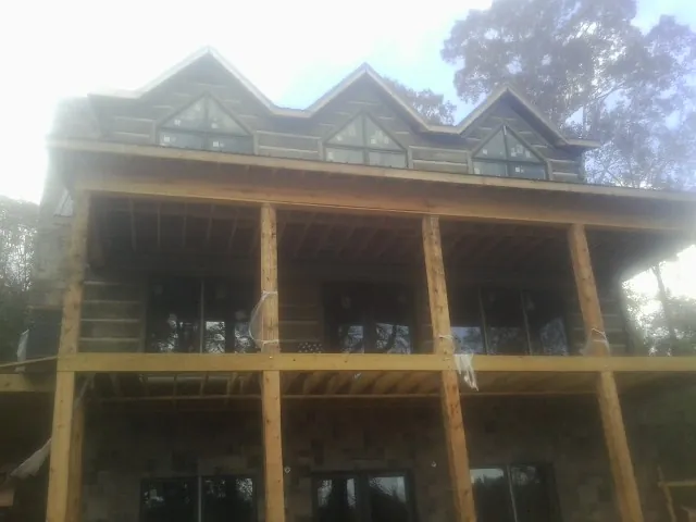Dormers and porch framing on a large log home under construction — Roof Coating work by our crew in West Chazy