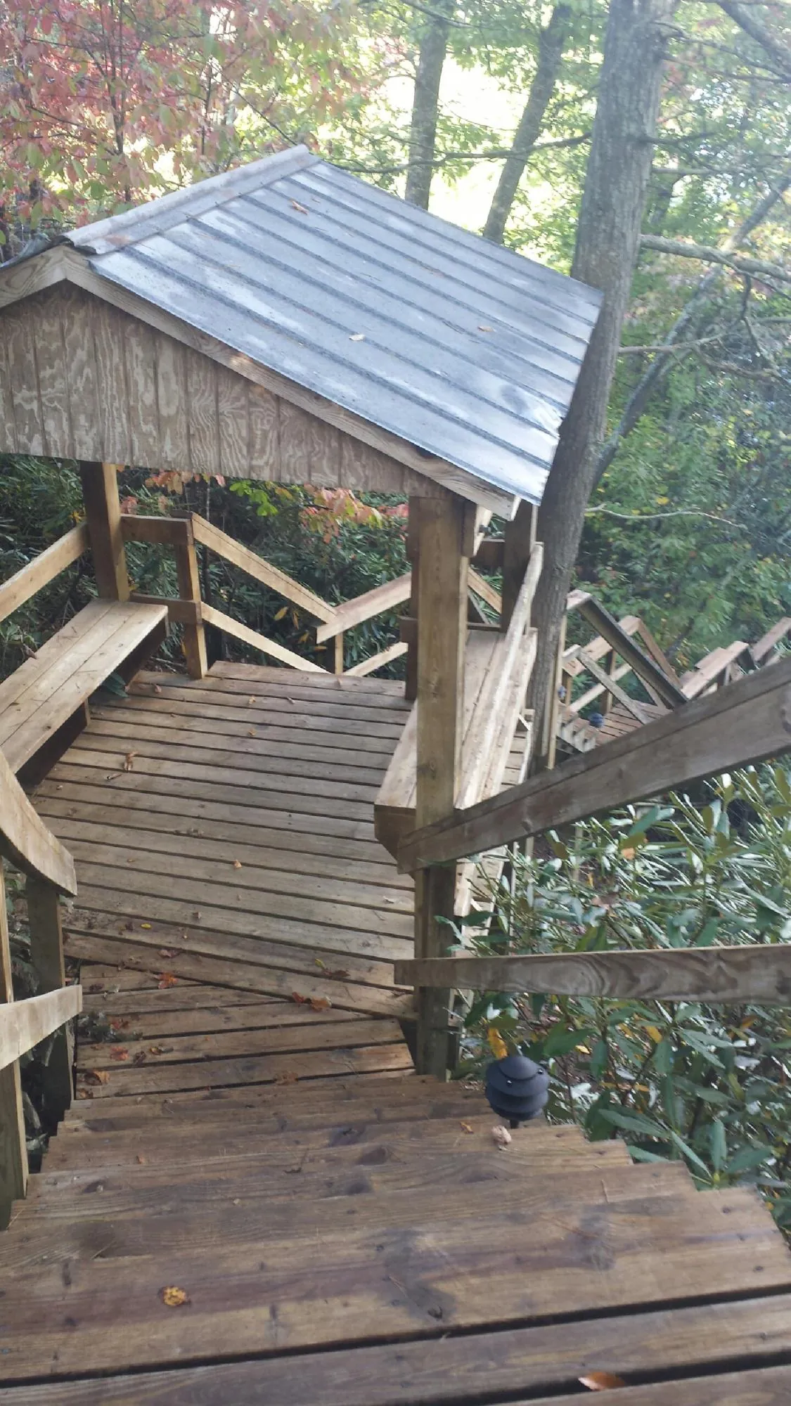 Metal roofed shelter over wooden steps on a wooded walkway — Skylight Repair & Installation work by our crew in West Chazy