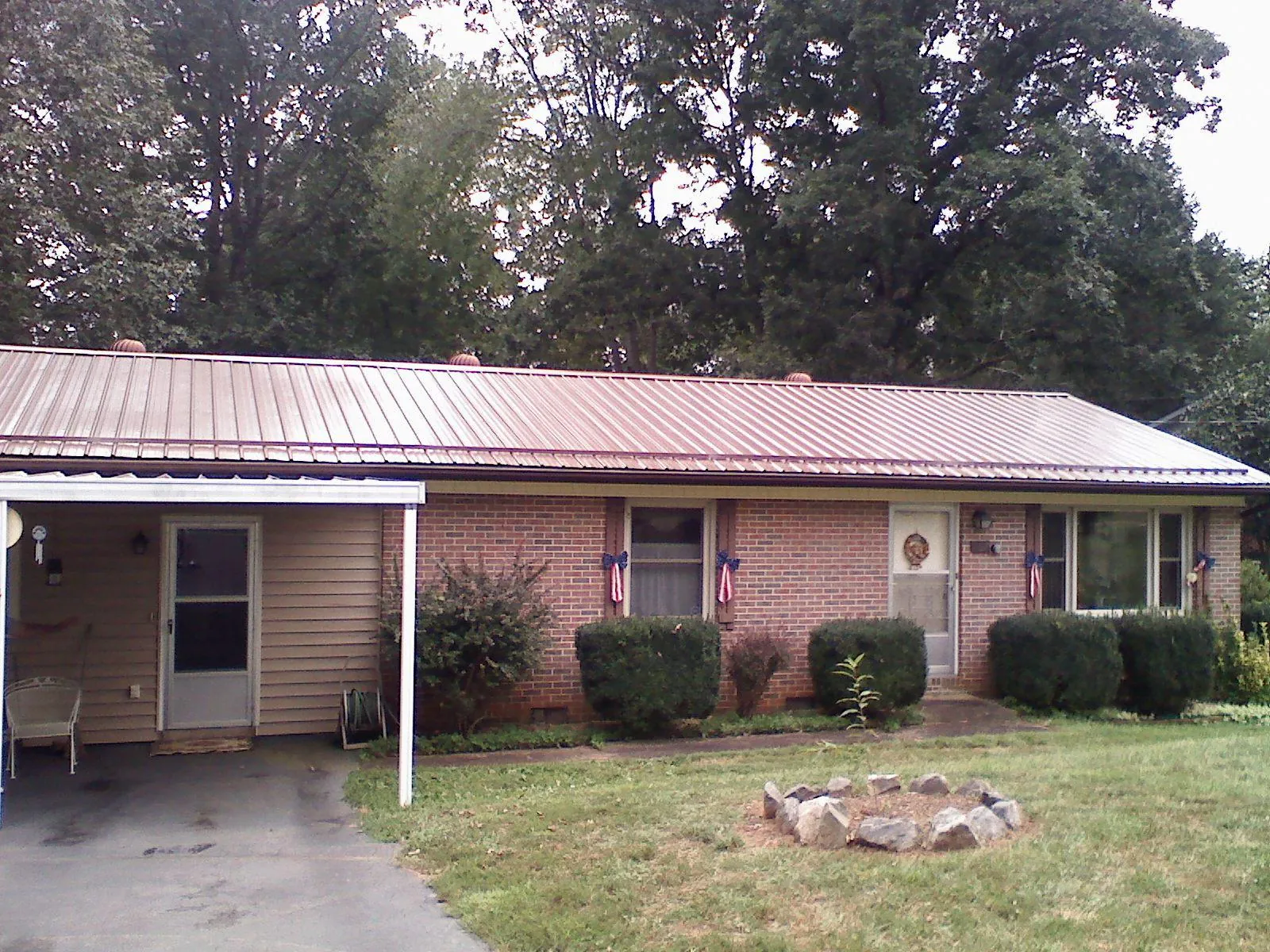 Bronze metal roof and carport on a brick ranch home — Roof Repair work by our crew in West Chazy