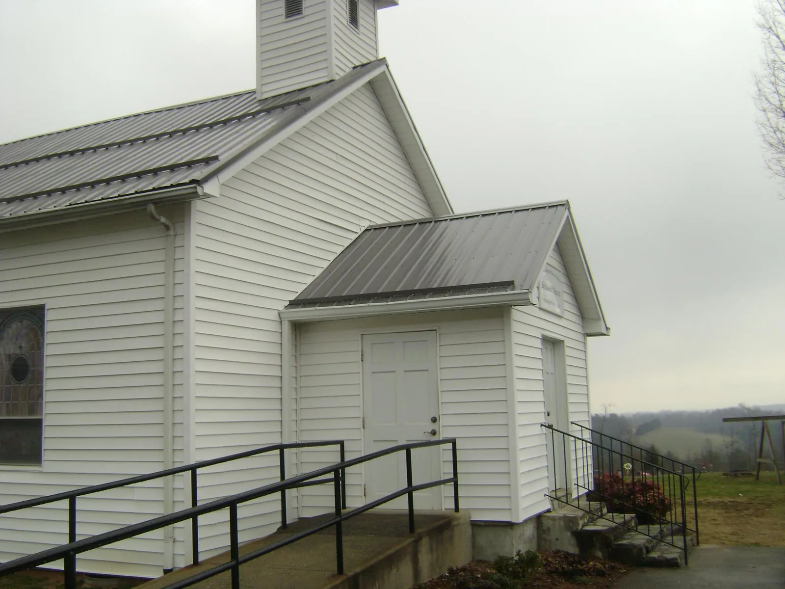 Gray metal roof on a white clapboard church with a steeple in West Chazy